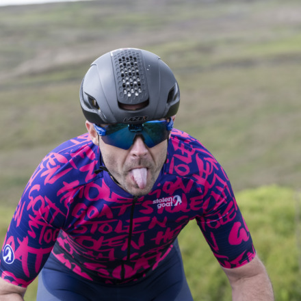 Man in race team kit sticking his tongue out
