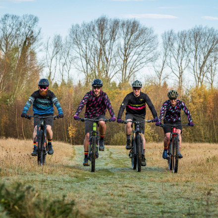 4 off-road cyclists cycling in a field