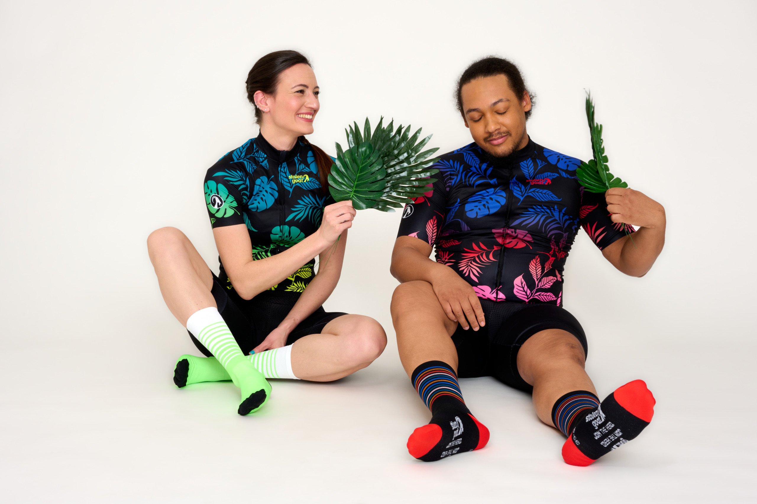 man and woman in cycling kit fanning faces with palm leaves