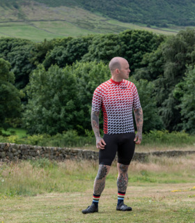 Full length shot of male model in Durutti jersey and black shorts against a countryside back drop