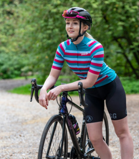 Woman resting her arms on her bike handlebars wearing Roxy jersey