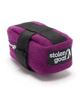 Side view of Stolen Goat Harris Tweed saddle bag purple tweed with black and white stolen goat logo label, black velcro strap, metal zip
