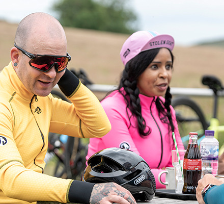 man and woman at a cafe wearing mango and pink alpine epic jackets