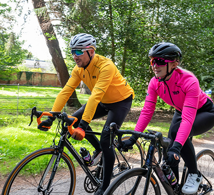 man and woman riding bikes wearing mango and pink alpine epic jackets