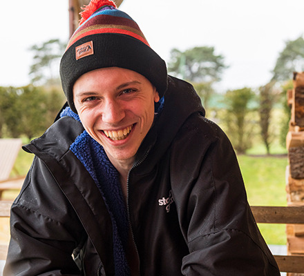 man wearing change thingy and bobble hat laughing