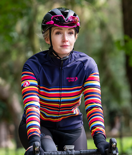 Woman riding bike wearing Dizzy Alpine Bodyline jacket, looking straight ahead