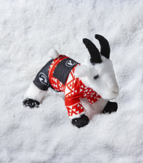 white plush goat toy wearing red christmas jumper
