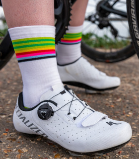 Close up of someone wearing Lithium cycling socks with white cycling shoes on