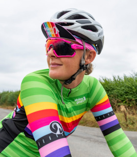 Woman wearing women's Lithium cycling jersey green tonal stripe with rainbow block stripe