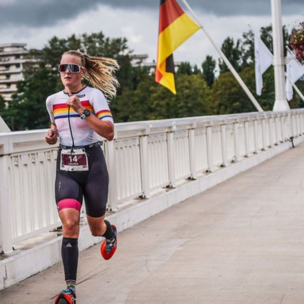 Pro triathlete Laura Addie running at Ironman Vichy 70.3 2022 wearing the Stolen Goat Jaffa tri suit