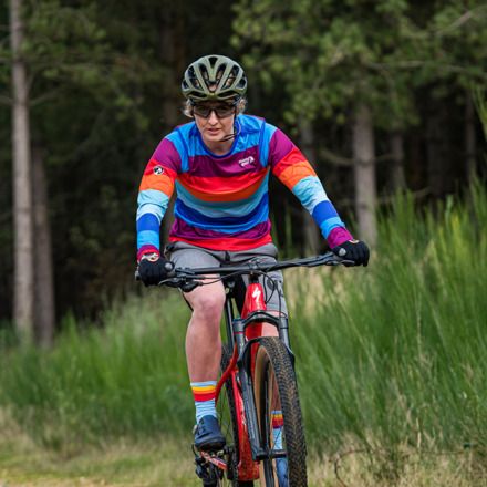 Woman riding a mountain bike wearing hinterland mtb jersey